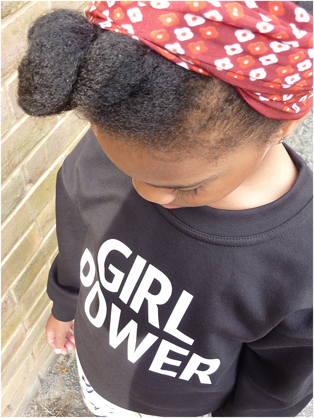 Little black girl wearing enpowering Girl Power slogan sweater from a collaboration with Lux and Black and Mini Edit